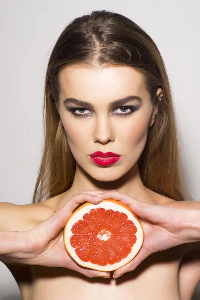 Glamour girl anläggning grapefrukt — Stockfoto