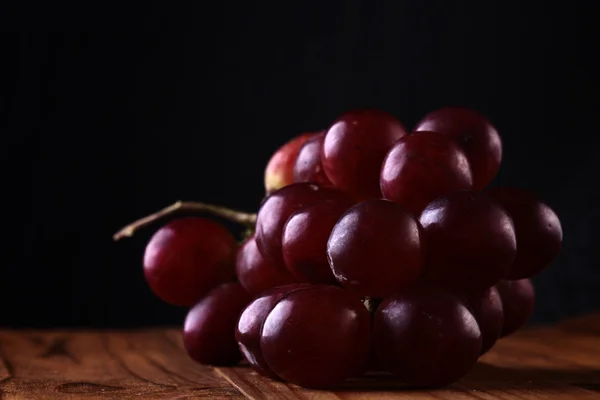 木制的桌子上的红葡萄品种 — 图库照片