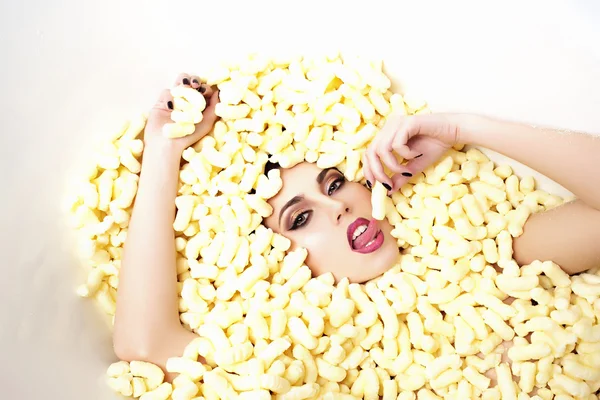 Fashionabla kvinna i corn sticks heap — Stockfoto