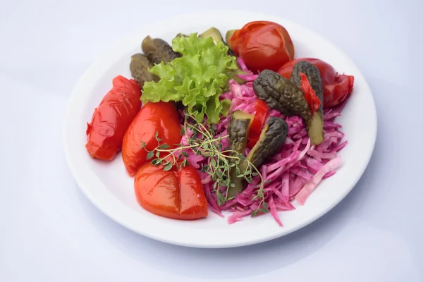 Маринованные овощи на белой тарелке — стоковое фото