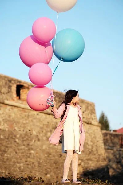 Little girl holding balloons full size, outdoor — Stock Photo, Image