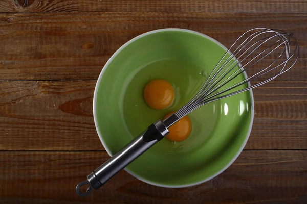 Eggs and beater on green plate — Stock Photo, Image