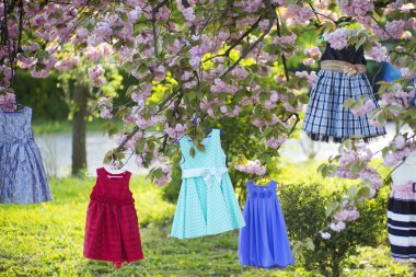 Children's dresses on the tree clipart