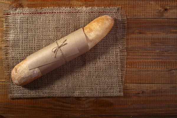 Loaf of baguette in paper packet — Stock Photo, Image