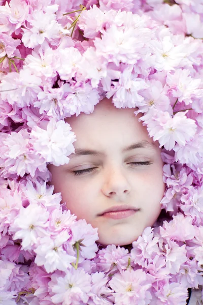 Rosto de menina pequena entre flores — Fotografia de Stock