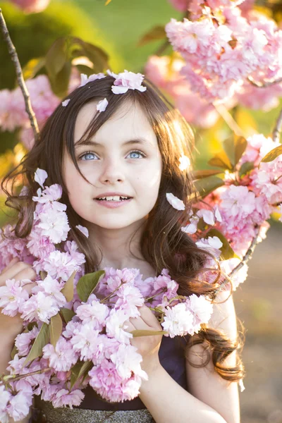 Kleines Mädchen inmitten der Kirschblüte Stockfoto