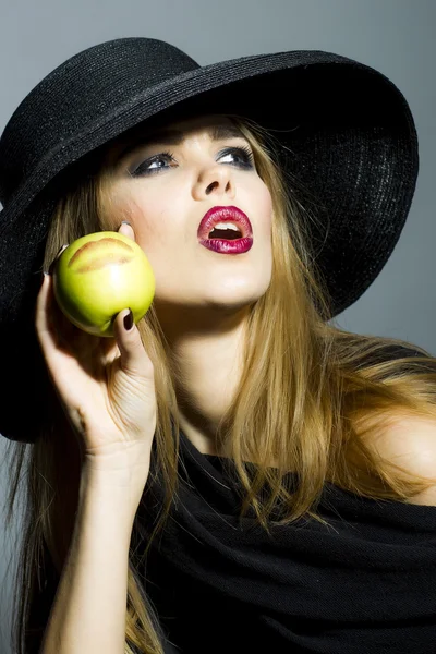 Vacker flicka i retro svart hatt med äpple — Stockfoto