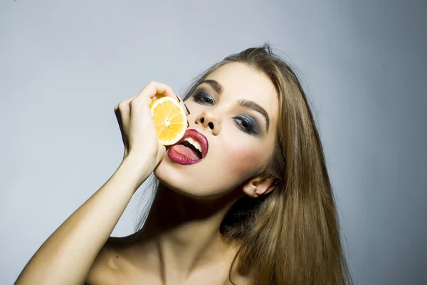 Sexy blonde meisje portret met oranje — Stockfoto