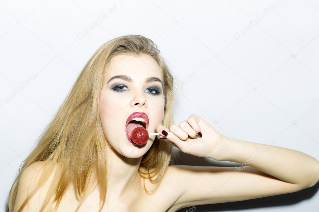 Passionate blonde girl portrait with sugar candy 