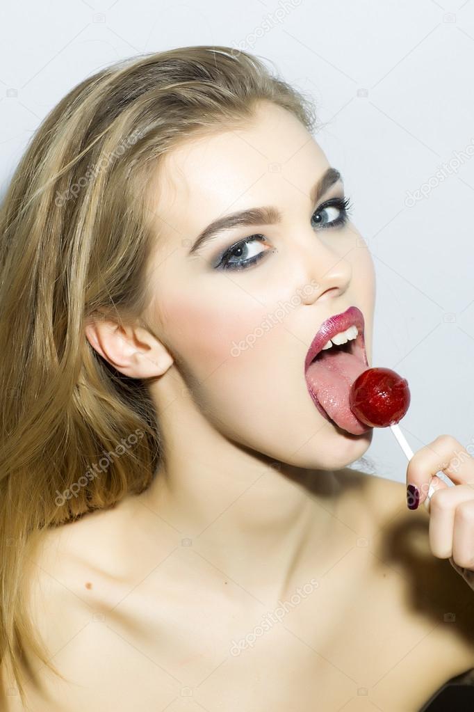 Magnetic young blonde girl portrait with sugar candy 