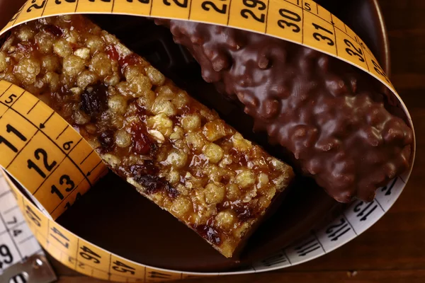 Savoureuses barres de chocolat et cacahuètes cassantes avec un ruban à mesurer — Photo