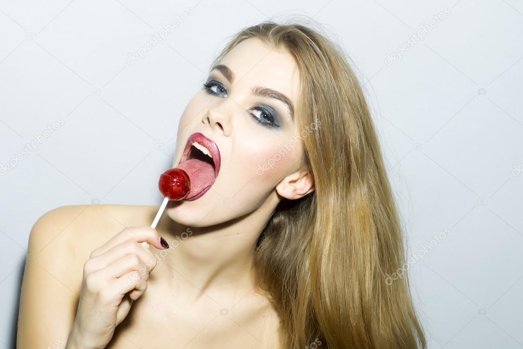 Playful young blonde woman portrait with sugar candy 