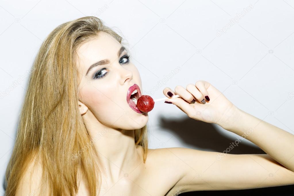 Passionate blonde young woman portrait with sugar candy 