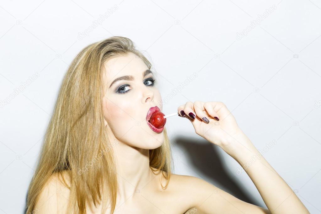 Impassioned blonde young woman portrait with sugar candy 