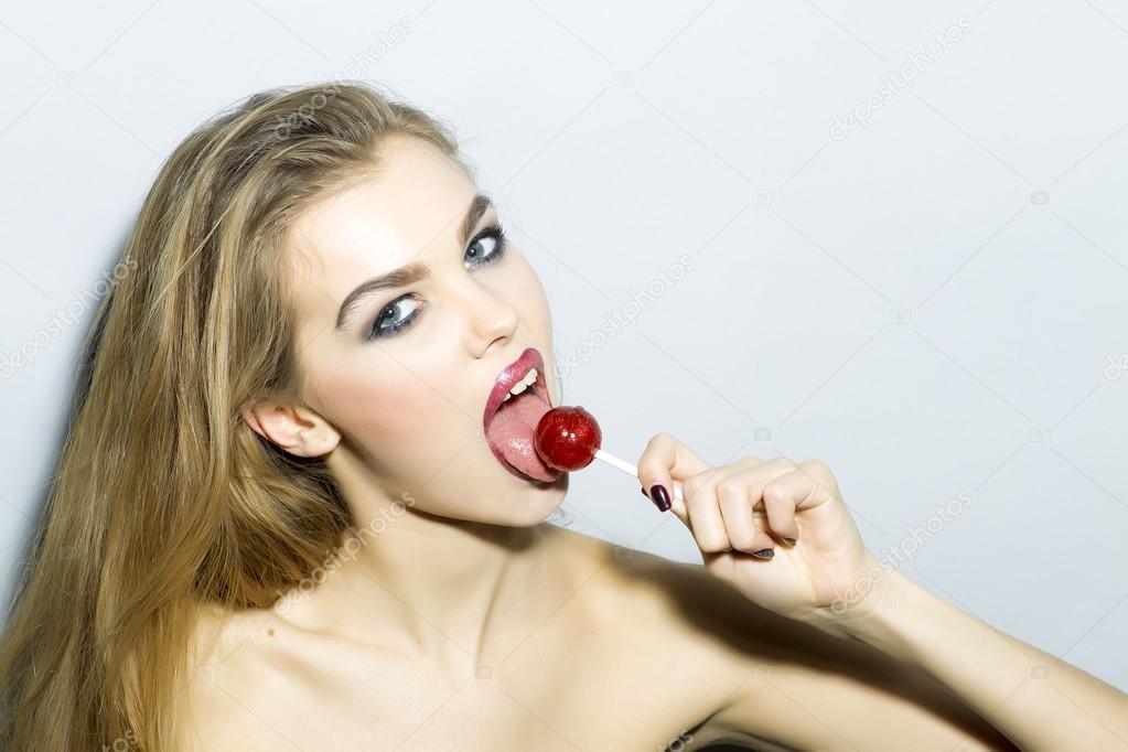 Magnetic young blonde woman portrait with sugar candy 