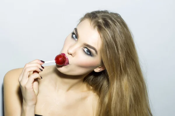 Retrato de mulher loira jovem cativante com doces de açúcar — Fotografia de Stock