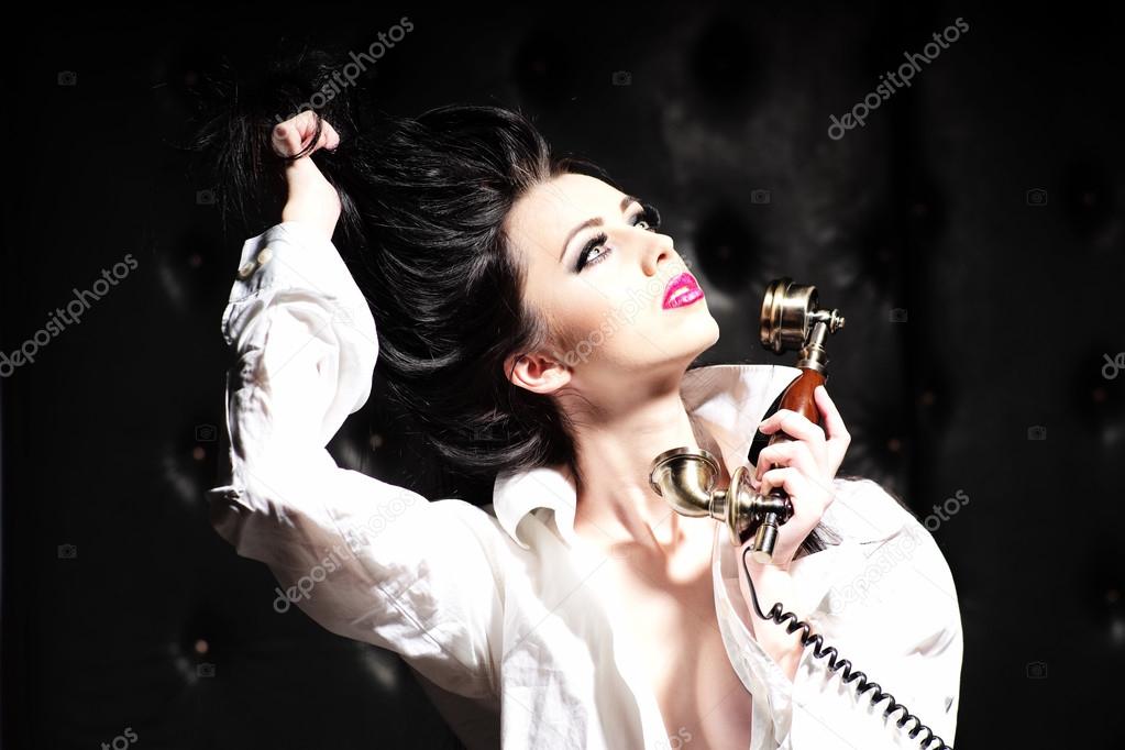 Sexy brunette woman and gold telephone