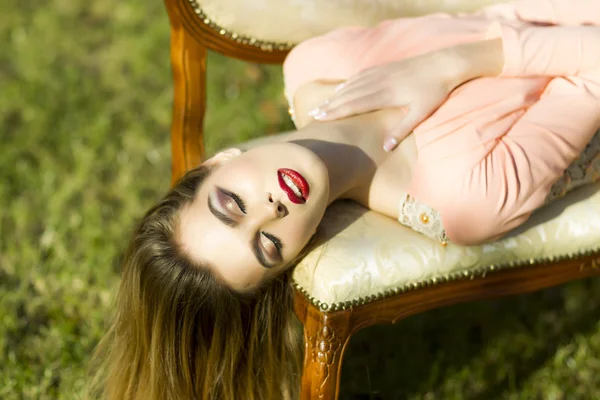 Menina bonita no sofá ao ar livre — Fotografia de Stock