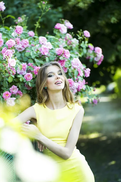 Smiling woman and pink roses — Stock Photo, Image