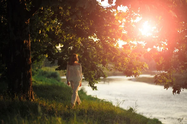 Hermosa mujer al atardecer cerca del río —  Fotos de Stock