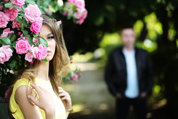 Mujer y hombre cerca de rosal — Foto de Stock