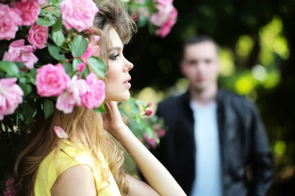 Namiętna kobieta i mężczyzna w pobliżu rose bush — Zdjęcie stockowe