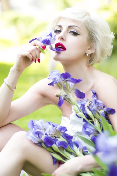 Mulher loira com flores de íris — Fotografia de Stock