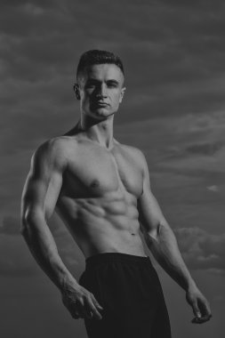 Sexy bodybuilder on sky background