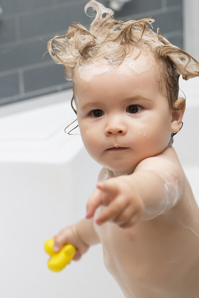 Little boy in bath with toy