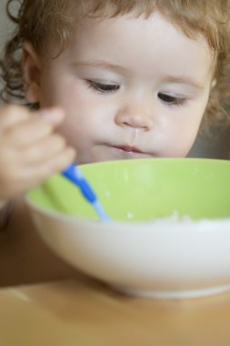 Portrait of serious male child eating