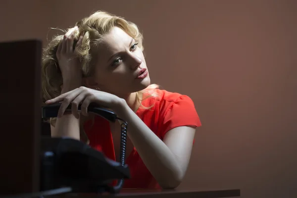 Bored female secretary with phone — Zdjęcie stockowe