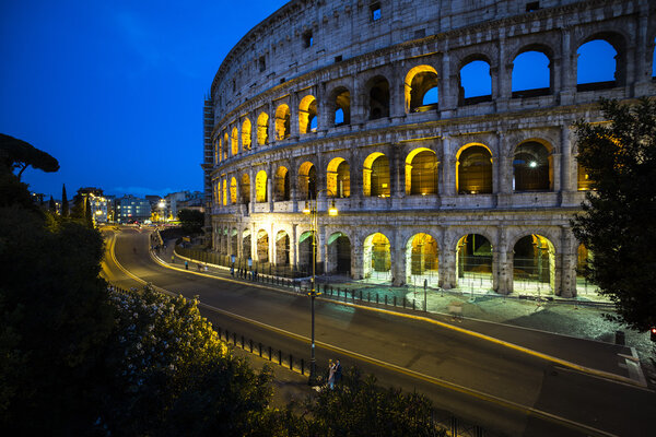 Magnificent evening Coliseum or Amphitheatrum Flavium with bright illumination on blue sky background, Rome, Italy