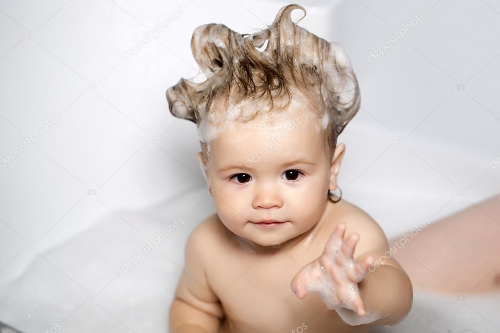 Cute baby with funny hairstyle in bathtub