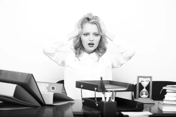 Upset woman at office table — Stock fotografie