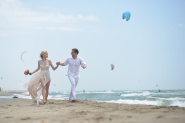 Running wedding couple on beach