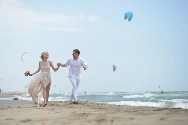 Running wedding couple on beach — 图库照片