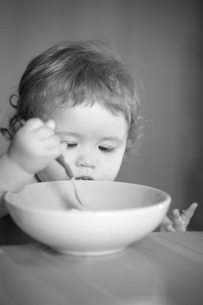 Portrait of curious male kid eating — Stock Photo, Image