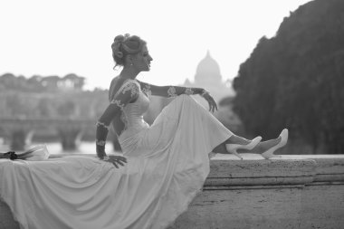 Sensual bride sitting on bridge