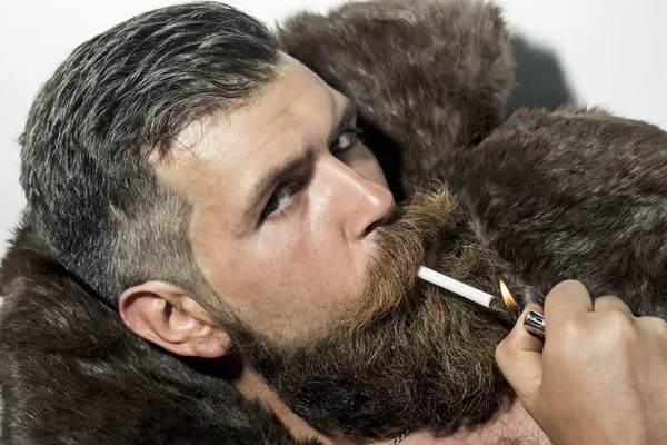 Sexual man in fur coat smoking — Stock Photo, Image