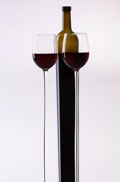 Stretched wine bottle and glasses — Stock Photo, Image