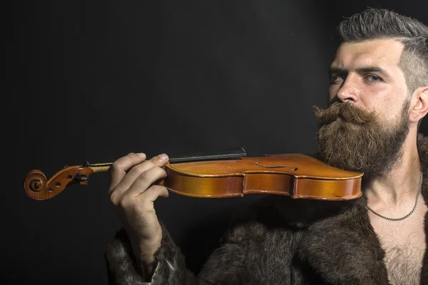 Man in fur coat with violin — Stockfoto