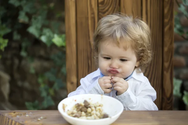 Funny babyjongen buiten eten — Stockfoto