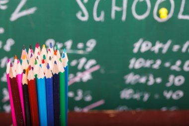 Colorful pencils and school blackboard