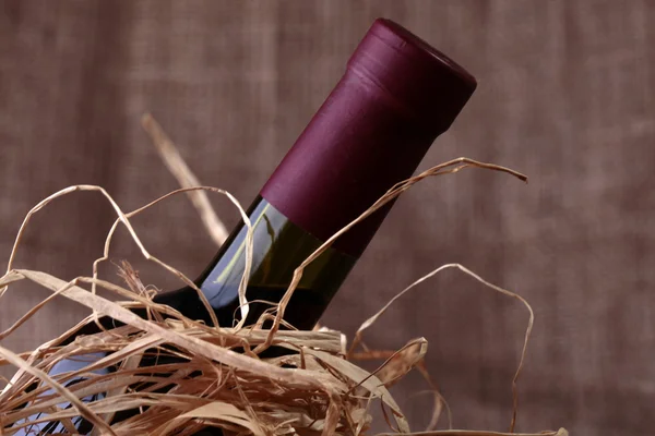 Wine bottle in straw — Stockfoto