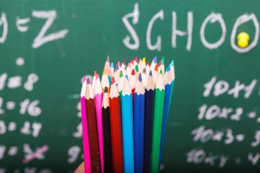 Colorful pencils and school blackboard