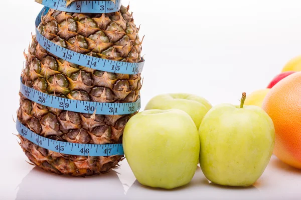 Pineapple apple orange and measuring tape — Stok fotoğraf