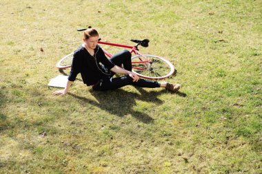 Man with bycicle on grass