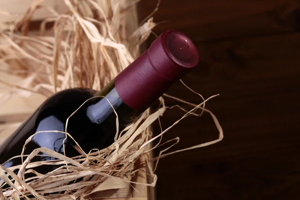 Volledige fles rode wijn in vak — Stockfoto