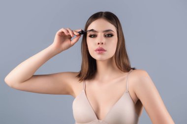 Eyebrow makeup. Beauty model shaping brows with brow pencil closeup. Womans eyebrows with eyebrow brush. Natural make up. Modeling brows. Comb eyebrows