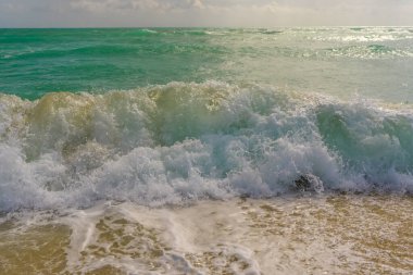 Okyanus dalgaları arka planı. Tropik okyanus dalgaları. Mavi deniz manzaralı. Köpüklü sahil şeridi. Kumsal sahili arka planı. Yaz seyahati ve tatil. Mavi deniz dalgası